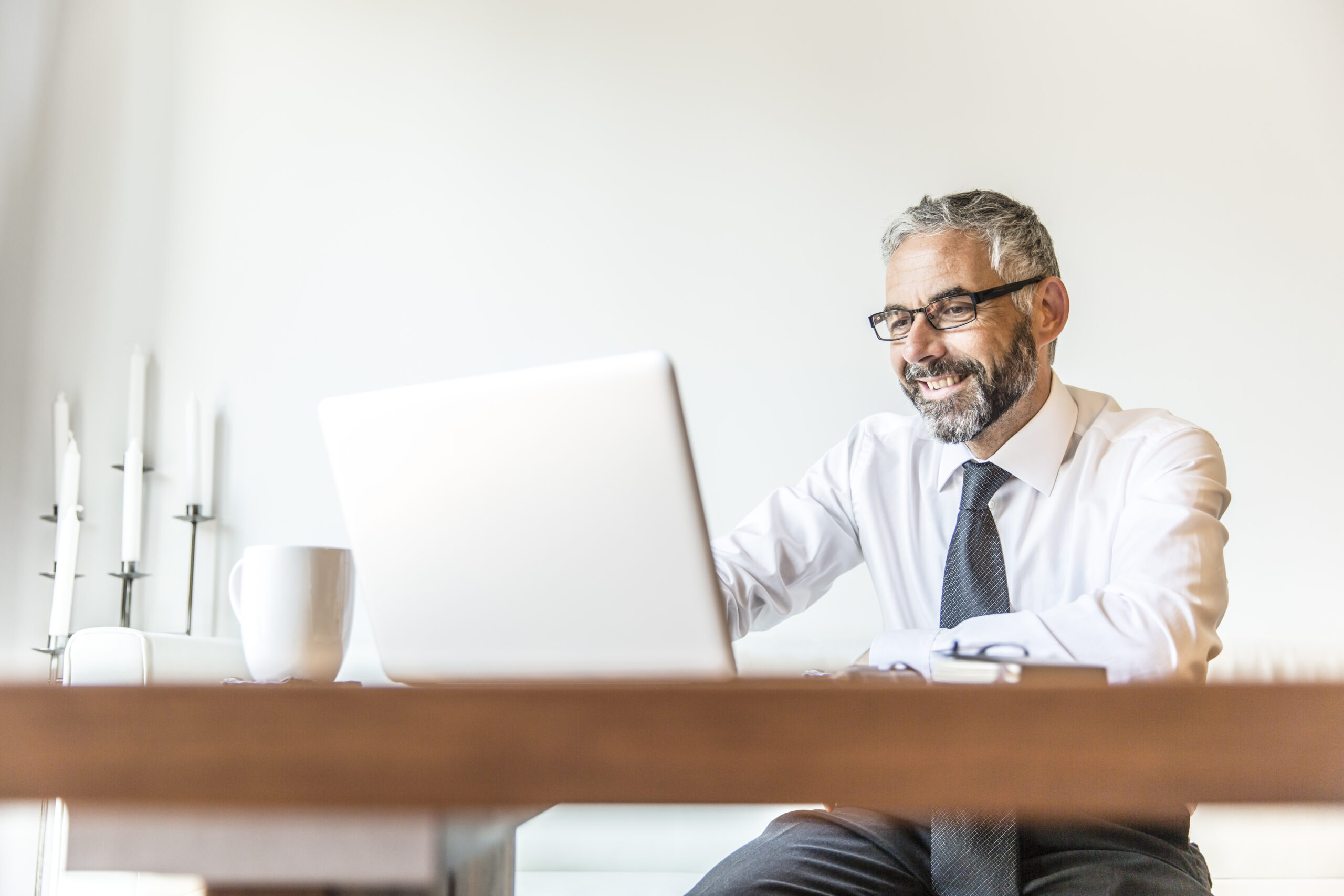 Portrait of smiling businessman working at home office Manon Lemay Coaching - Chaque individu possède en lui les ressources nécessaires pour réussir